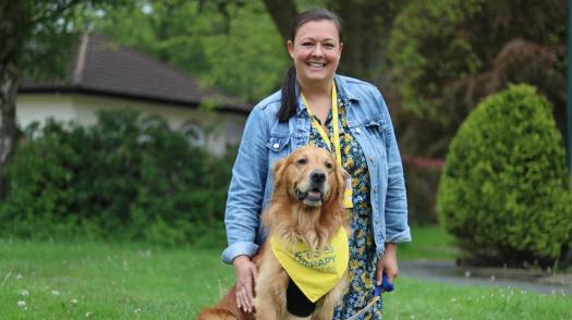 Lee and her PAT dog Mac, sitting outside on the grass