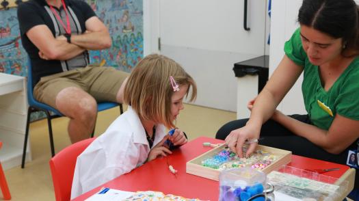 Marnie making a beaded bracelet.