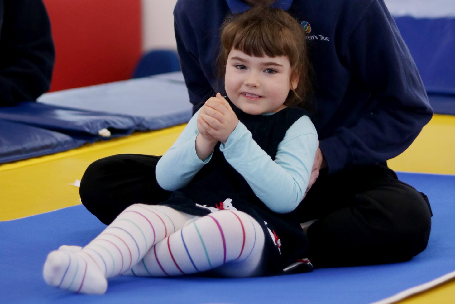 Olivia sat on the trampoline during a rebound therapy session at The Children's Trust