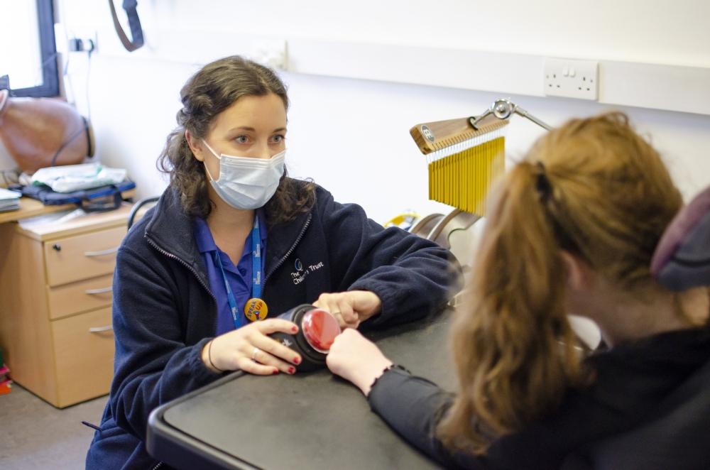 Music therapist helping a young person operate a switch