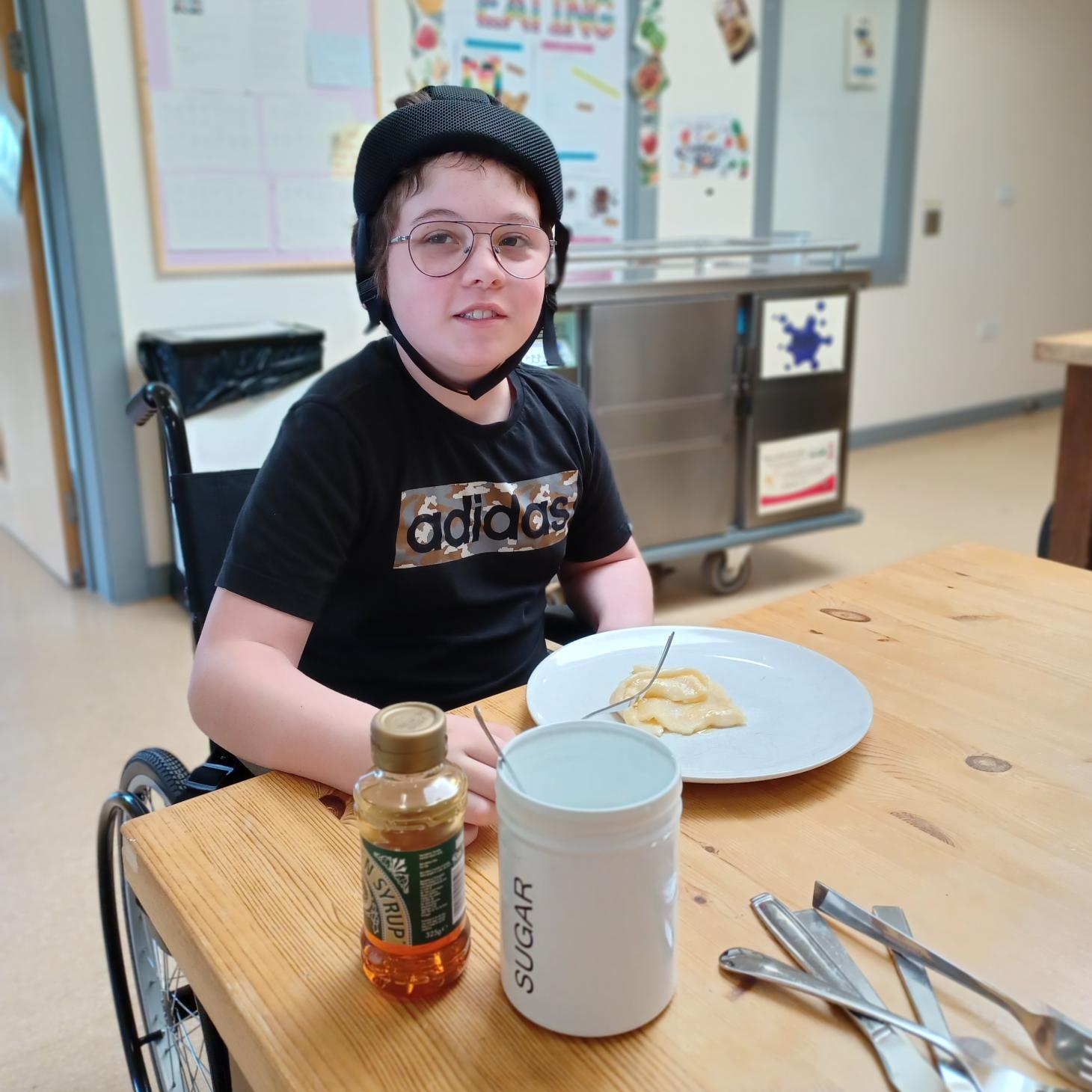 Riley sitting in front of a plate of pancakes