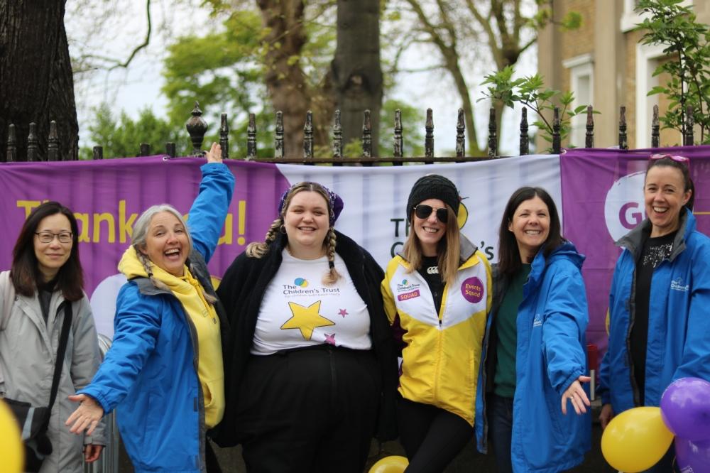 A group of staff volunteers in branded t shirts smiling 