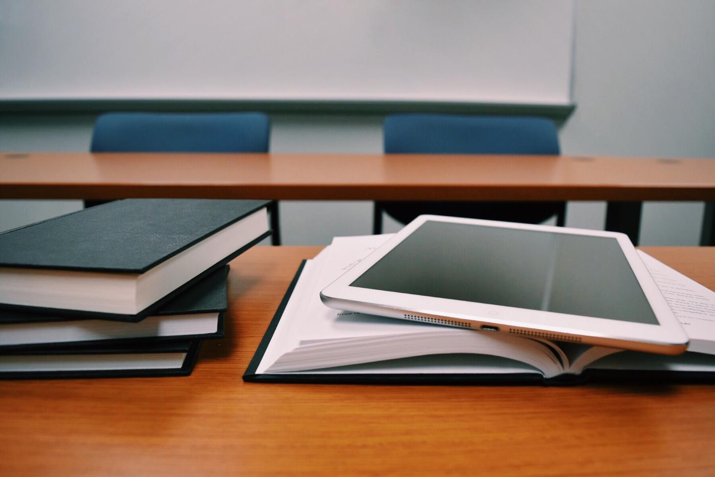 college classroom desk with books and iPad