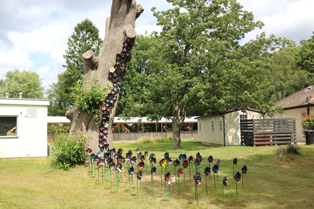 Lots of handmade flowers displayed around and on a tree