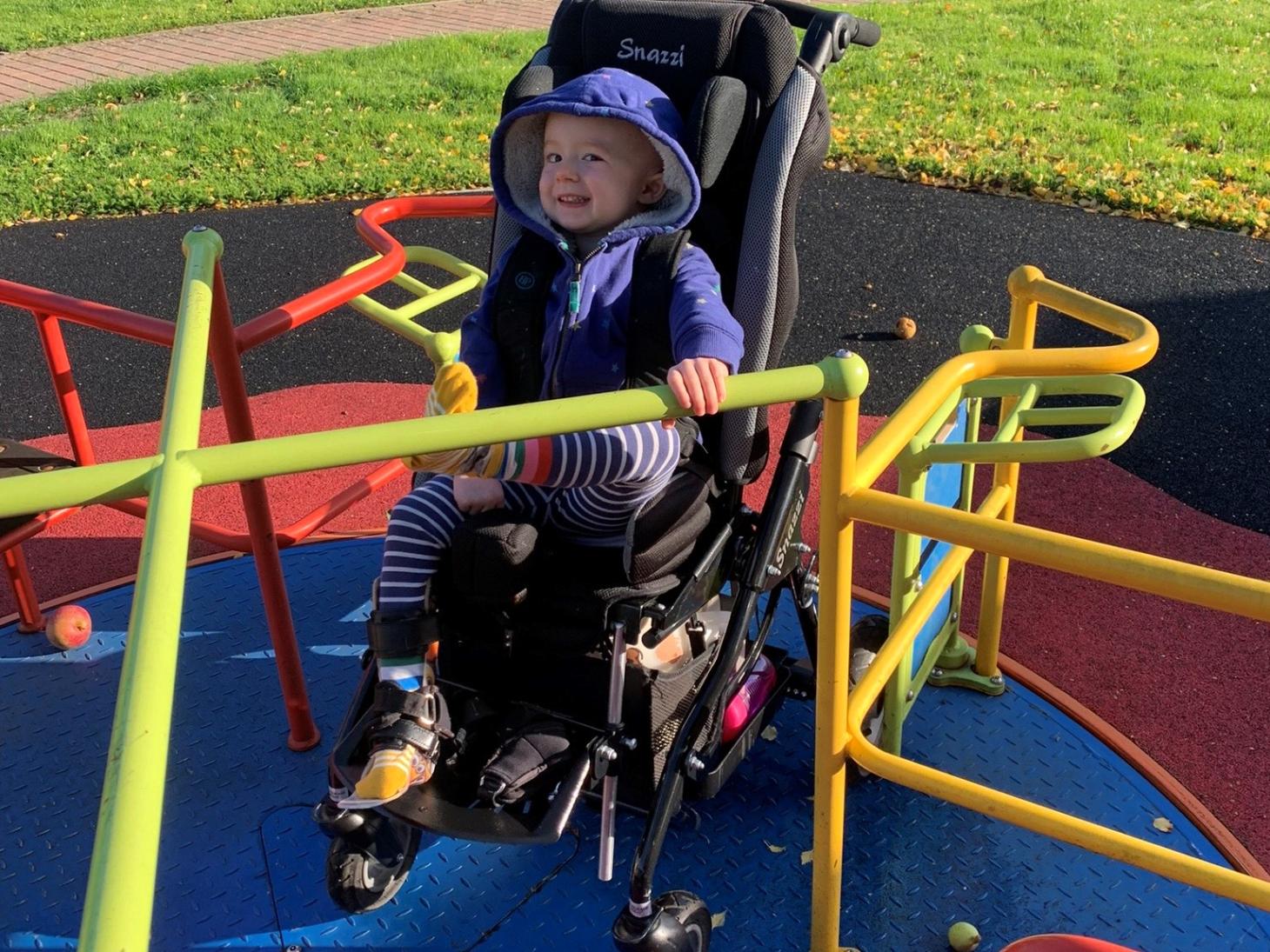 Millie on a wheelchair accessible roundabout