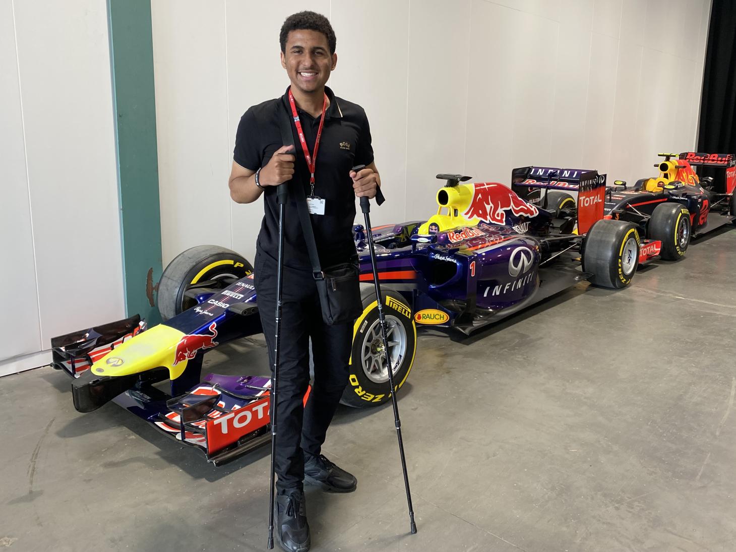 Zac standing in front of race cars