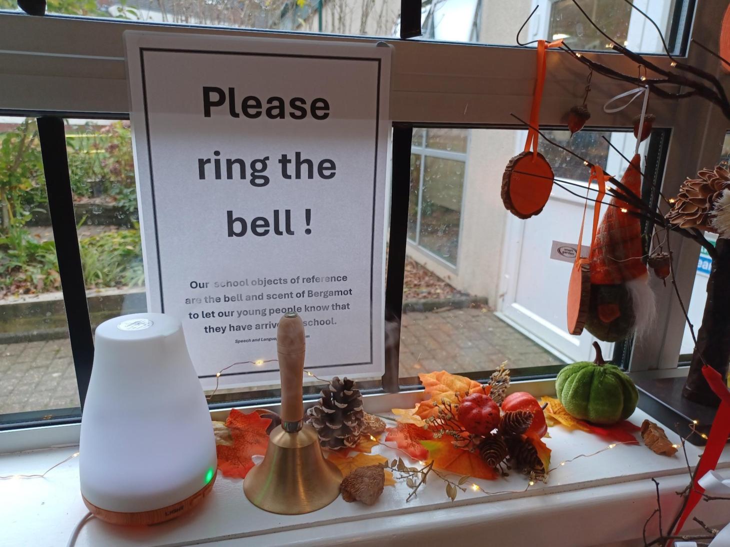 diffuser, bell and sign sits on a windowsill