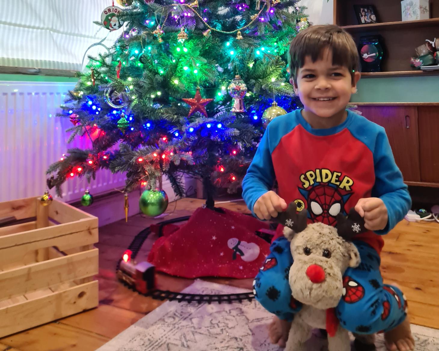 Orion smiling in front of a Christmas tree