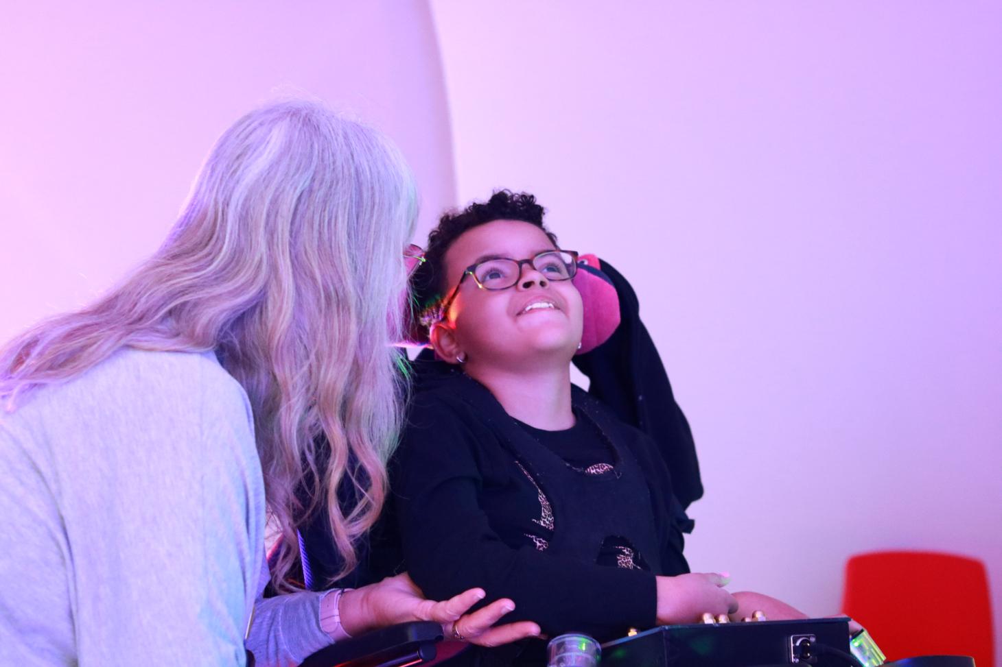 child using sensory board assisted by adult