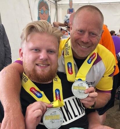 mark and ryan, father and son hold their superhero tri medals 