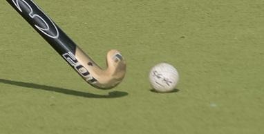 hockey stick and ball on a pitch