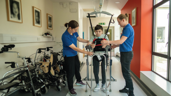 Leo in a therapy session using the Guldmann Hoist with therapists