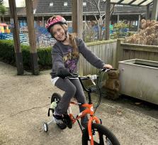 Violet on a bike at The Children's Trust