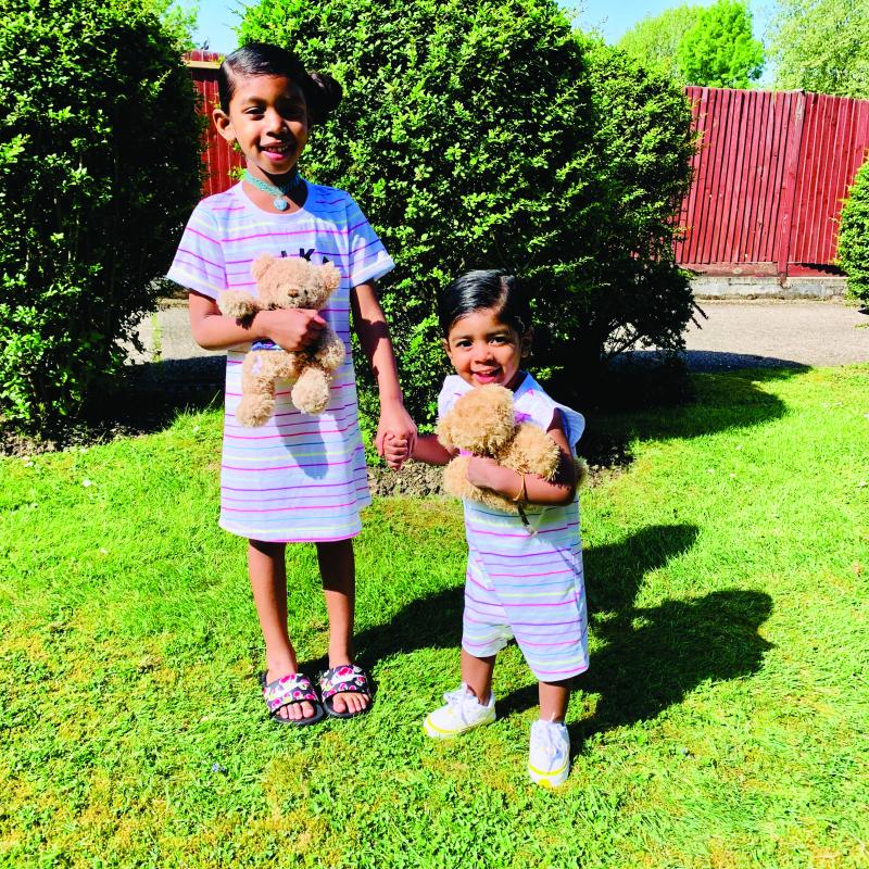 Saffron at home with family holding a teddy bear