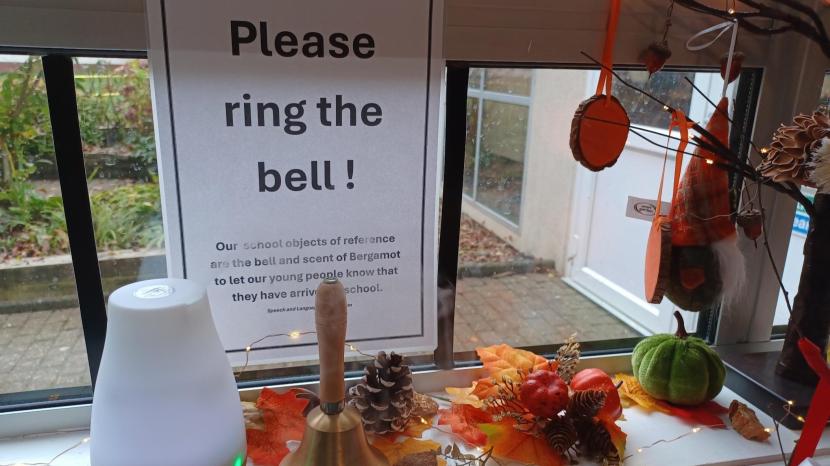 diffuser, bell and sign sits on a windowsill