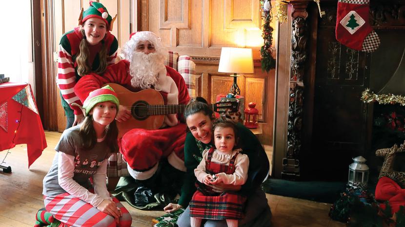 A mother and daughter visiting Santa and his elves in Santa's Grotto.