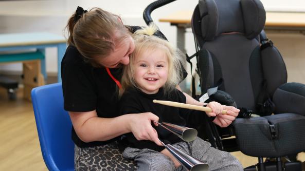 Liliana smiling playing a bell
